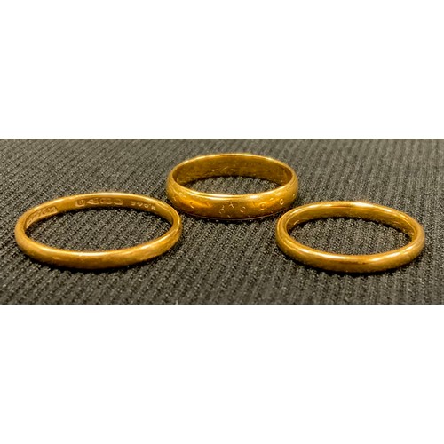 424 - Three 22ct gold wedding bands, 10g gross (3)