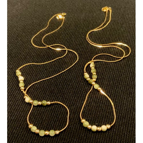 438 - A gold coloured metal and jade necklace, the jade spherical beads divided by gold coloured metal bea... 