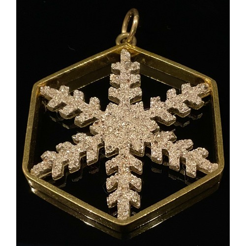 446 - A hexagonal yellow and white metal snowflake pendant, impressed marks, 10g gross