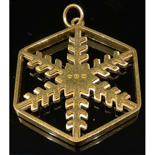 446 - A hexagonal yellow and white metal snowflake pendant, impressed marks, 10g gross