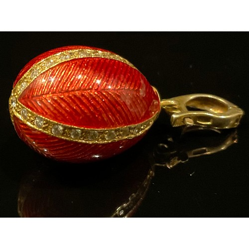 452 - A silver gilt red enamelled egg pendant, paste detailed quarters, stamped 925 sil, 5.5g gross