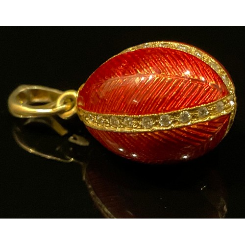 452 - A silver gilt red enamelled egg pendant, paste detailed quarters, stamped 925 sil, 5.5g gross