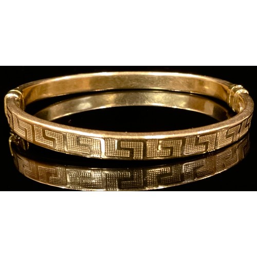 460 - A 9ct gold Hollow Greek Key hinge bangle, 8.2g