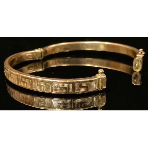 460 - A 9ct gold Hollow Greek Key hinge bangle, 8.2g