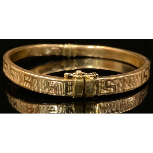 460 - A 9ct gold Hollow Greek Key hinge bangle, 8.2g