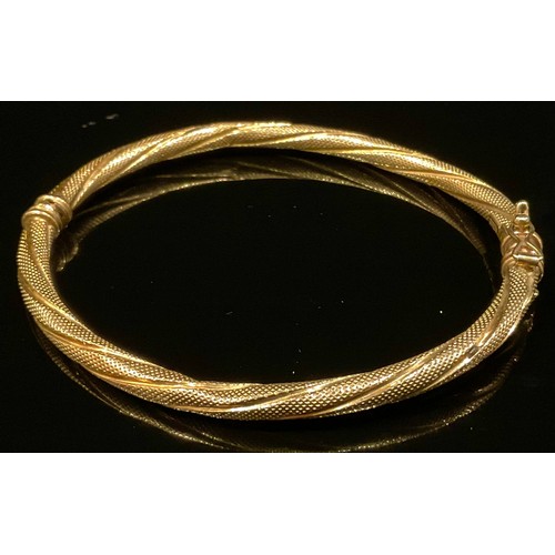 462 - A French 9ct gold fancy twisting hinge bangle, stamped 375 Brev, 5.2g