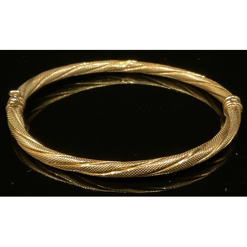 462 - A French 9ct gold fancy twisting hinge bangle, stamped 375 Brev, 5.2g