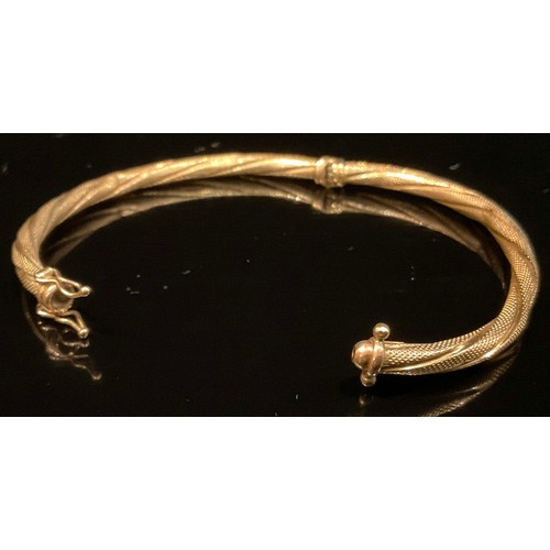 462 - A French 9ct gold fancy twisting hinge bangle, stamped 375 Brev, 5.2g