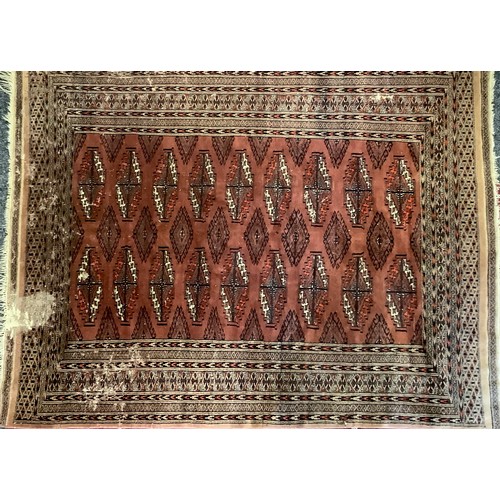 403 - A Middle Eastern woollen rug or carpet, stylised geometric motifs and borders in tones of red and bl... 