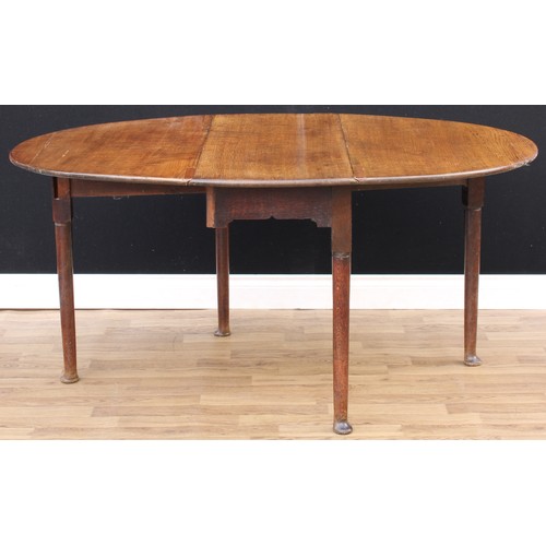 444 - A 'George II' oak gateleg dining table, oval top with fall leaves, cylindrical legs, pad feet, 72cm ... 