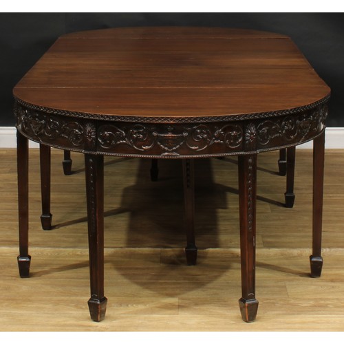 2424 - An Adam Revival mahogany dining table, discorectangular top above a deep frieze applied with urns an... 