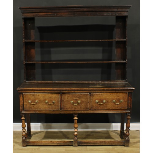 1989 - An 18th century design oak dresser, moulded cornice above three plate rack shelves, the projecting b... 