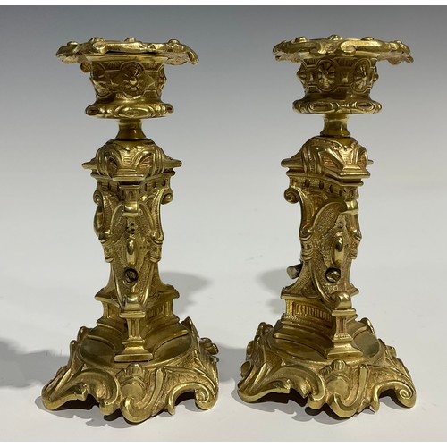 2082 - A pair of French Rococo style gilt bronze candlesticks, each stem with seated putti within sculpture... 