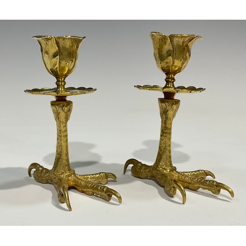 1826 - A pair of brass candlesticks, each base cast as an eagles foot, foliate moulded nozzles, shaped circ... 