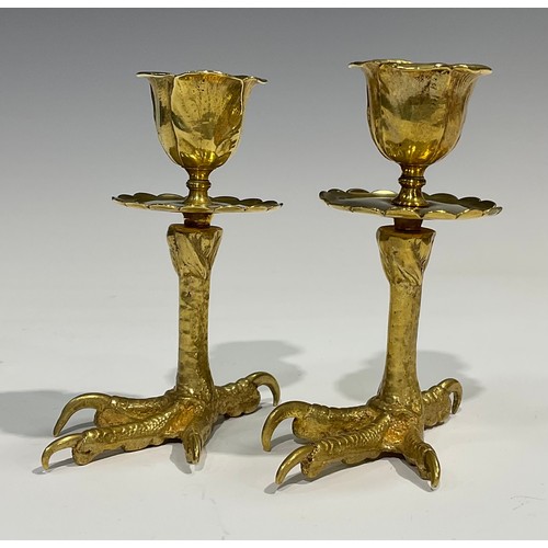 1826 - A pair of brass candlesticks, each base cast as an eagles foot, foliate moulded nozzles, shaped circ... 