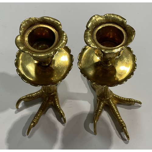 1826 - A pair of brass candlesticks, each base cast as an eagles foot, foliate moulded nozzles, shaped circ... 