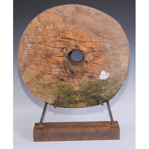 2218 - A rustic 19th century ox cart wheel, possibly Thailand, later mounted for display, 57cm high overall... 