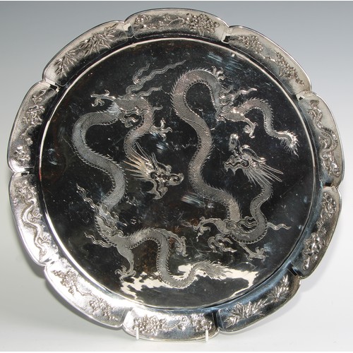 989 - A large Chinese silver shaped circular serving tray, the field engraved with a pair of dragons, the ... 