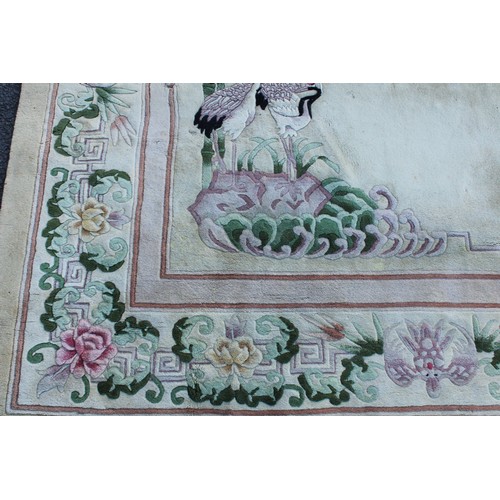 1771 - A Chinese wool carpet, worked in the Peking manner with Chinese pond herons, bamboo, flowers and lea... 