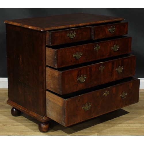 2351 - A Queen Anne walnut chest, featherbanded top above two short and three long graduated drawers, skirt... 