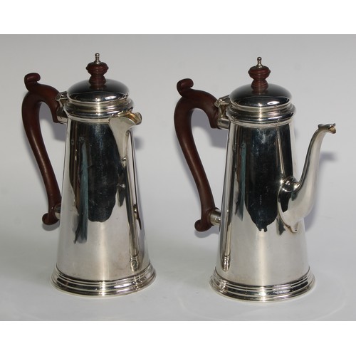 1069 - A silver spreading cylindrical coffee pot and hot water jug, in George I style, domed cover, composi... 