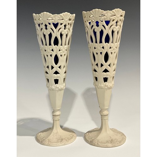 130 - A pair of 19th century Copeland Parian reticulated conical vases, pedestal bases, blue glass liners,... 