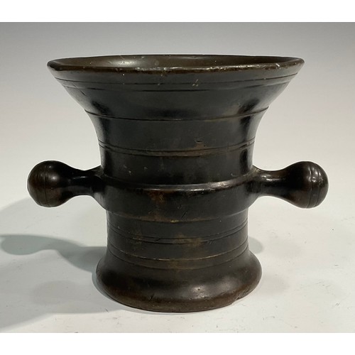 2342 - A 17th/18th century bronze mortar, flared rim above a centre girdle and reeded bands, bulbous handle... 