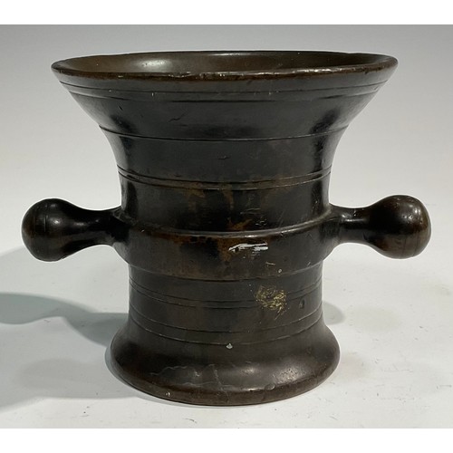 2342 - A 17th/18th century bronze mortar, flared rim above a centre girdle and reeded bands, bulbous handle... 