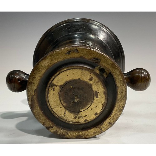 2342 - A 17th/18th century bronze mortar, flared rim above a centre girdle and reeded bands, bulbous handle... 