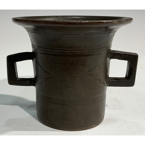 2342 - A 17th/18th century bronze mortar, flared rim above a centre girdle and reeded bands, bulbous handle... 