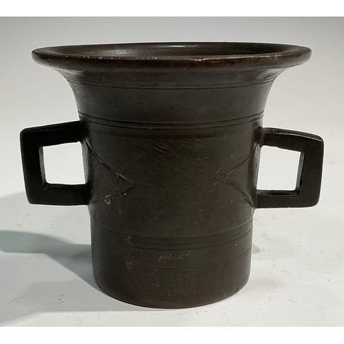 2342 - A 17th/18th century bronze mortar, flared rim above a centre girdle and reeded bands, bulbous handle... 