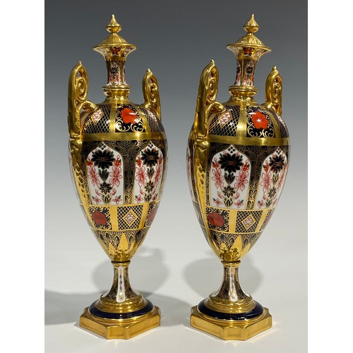 260 - A pair of Royal Crown Derby 1128 pattern pedestal ovoid vases and covers, spire finials, elaborate s... 