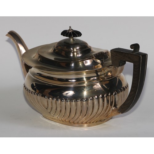 1166 - An Edwardian silver half-fluted boat shaped teapot, hinged cover, ebonised fittings, 30.5cm long, Ma... 