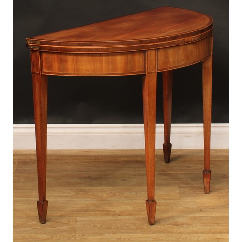 1796 - A George III mahogany demilune card table, hinged crossbanded top enclosing a baize lined playing su... 