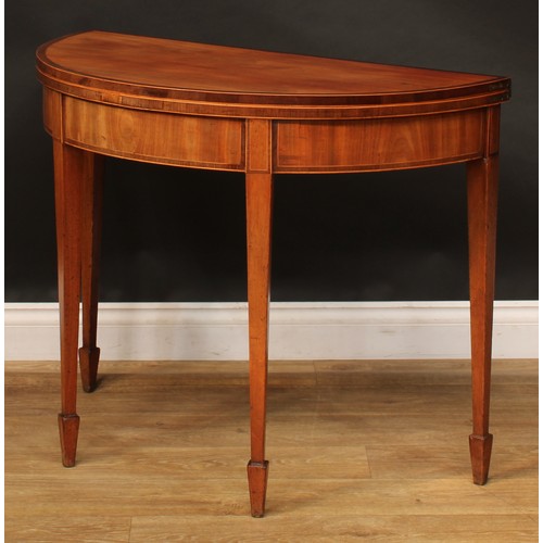 1796 - A George III mahogany demilune card table, hinged crossbanded top enclosing a baize lined playing su... 