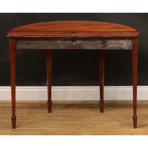 1796 - A George III mahogany demilune card table, hinged crossbanded top enclosing a baize lined playing su... 