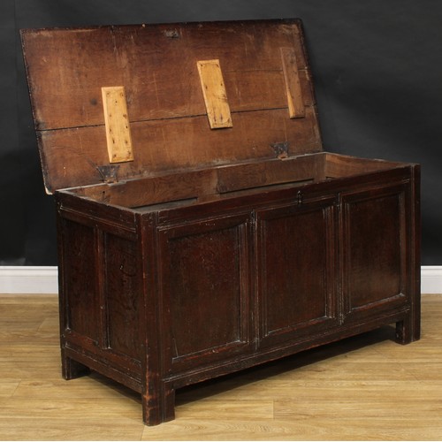 1570 - A 17th century oak blanket chest, hinged top, three panel front, stile feet, 69.5cm high, 129cm wide... 