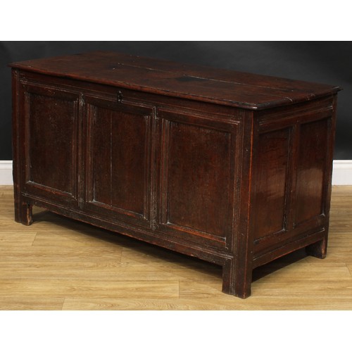 1570 - A 17th century oak blanket chest, hinged top, three panel front, stile feet, 69.5cm high, 129cm wide... 