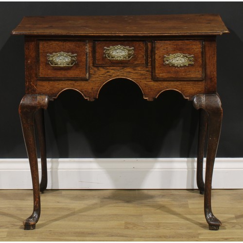 1946 - A George III oak lowboy, oversailing top above three frieze drawers, shaped apron, cabriole legs, po... 