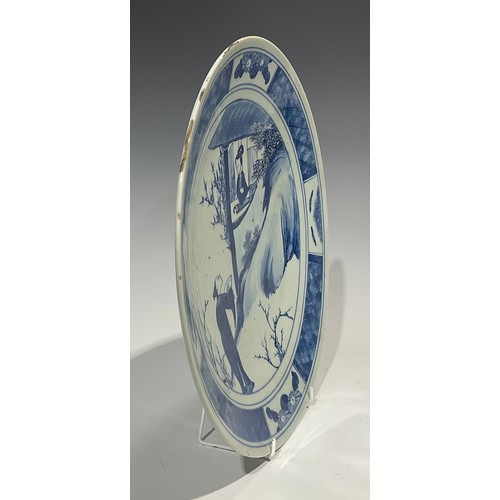 481 - An 18th century Chinese charger, decorated in underglaze blue with gentleman serenading a lady at a ... 