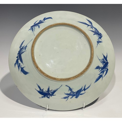 481 - An 18th century Chinese charger, decorated in underglaze blue with gentleman serenading a lady at a ... 