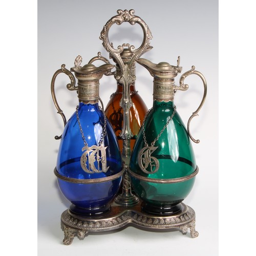 803 - A 19th century electroplated three bottle decanter stand, the freeblown glass decanters in green, bl... 