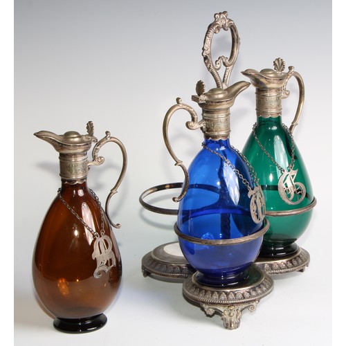 803 - A 19th century electroplated three bottle decanter stand, the freeblown glass decanters in green, bl... 