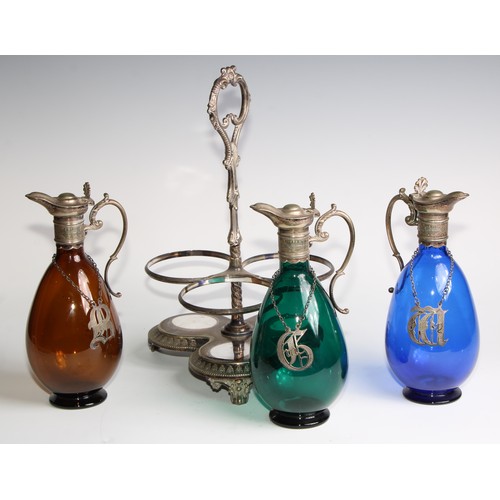 803 - A 19th century electroplated three bottle decanter stand, the freeblown glass decanters in green, bl... 