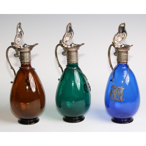 803 - A 19th century electroplated three bottle decanter stand, the freeblown glass decanters in green, bl... 