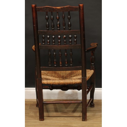 1595 - A 19th century fruitwood and elm spindleback elbow chair, rush seat, turned fore stretcher, 105cm hi... 