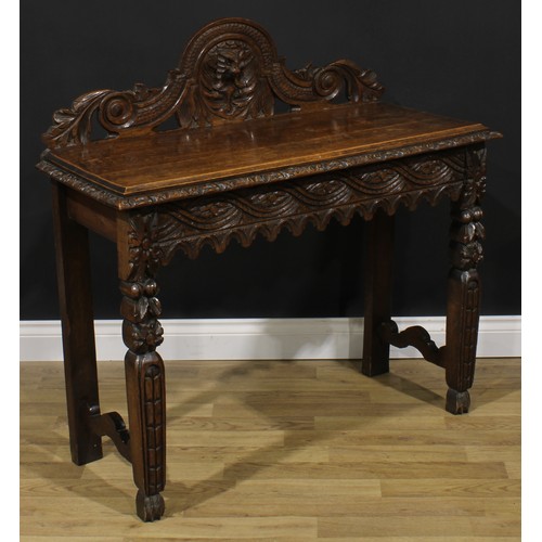 1958 - A late Victorian oak side or serving table, shaped half-gallery centred by a Green Man mask, oversai... 