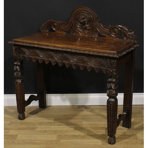 1958 - A late Victorian oak side or serving table, shaped half-gallery centred by a Green Man mask, oversai... 