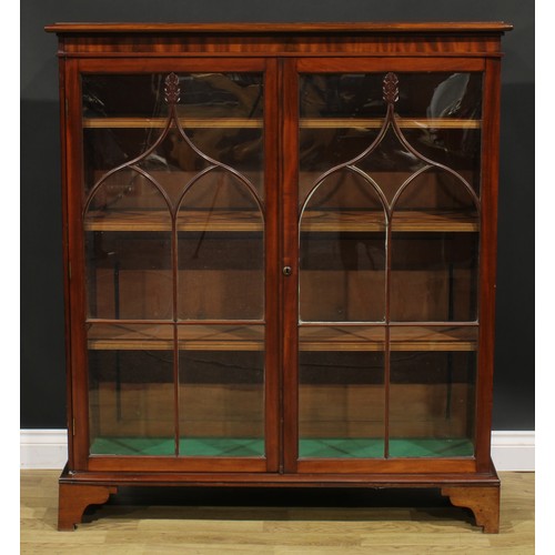 1634 - A 19th century mahogany low library bookcase, oversailing top above a pair of glazed doors enclosing... 