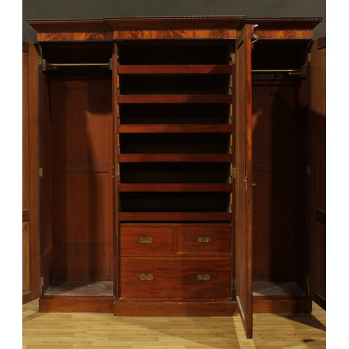 2265 - A Victorian mahogany break-centre wardrobe, outswept cornice with reel edge above three panel doors,... 